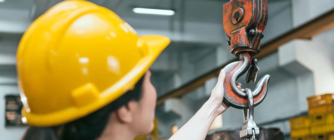 Frau nutzt Hebelkraft einer Krananlage